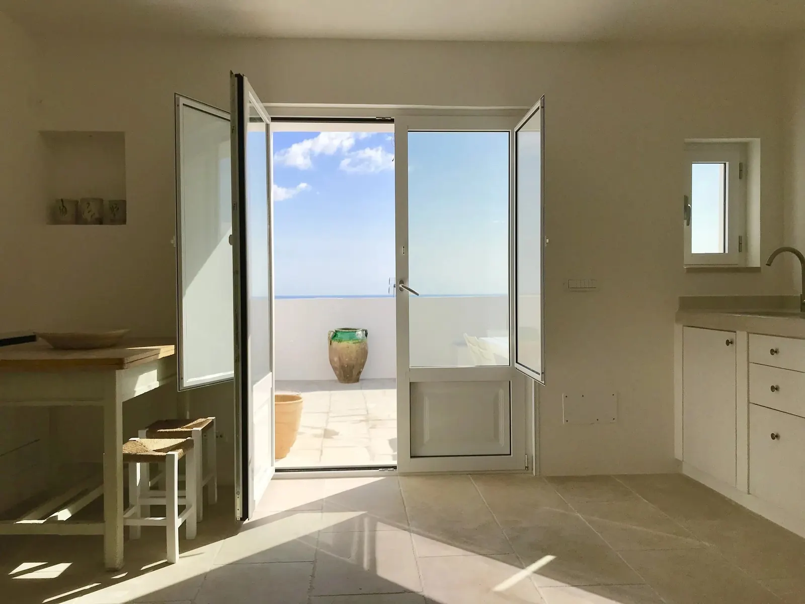 Kitchen with doors open onto the terrace and sea view