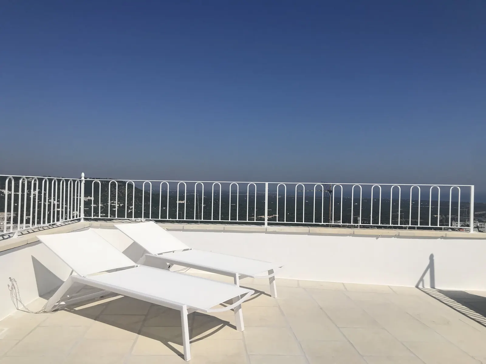 Upper terrace sun loungers facing the sea