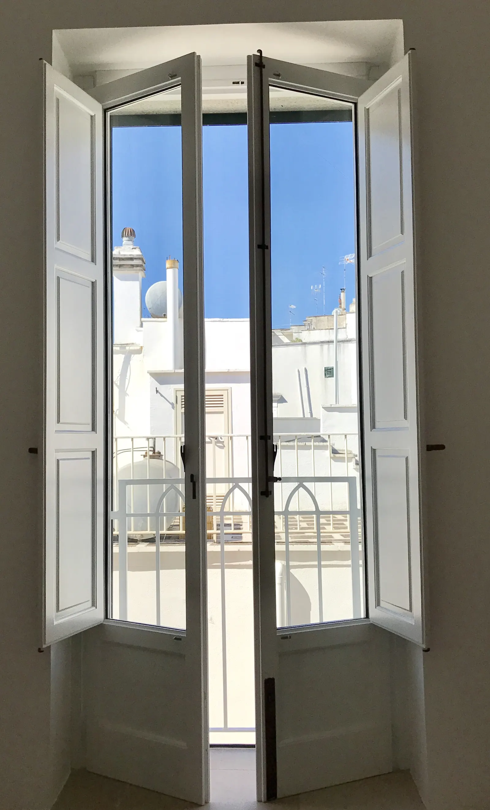 Tall windows open onto the balcony