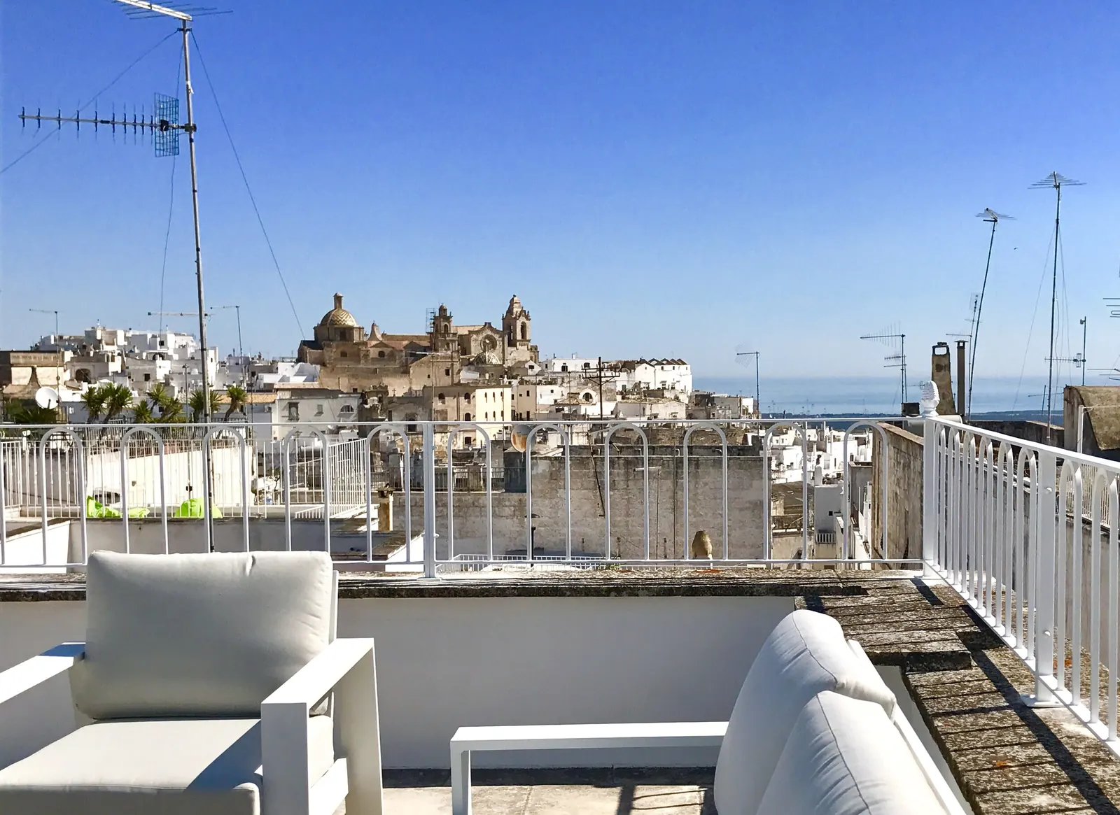 Rooftop terrace at Casa Palmira with views over Ostuni to the cathedral and sea