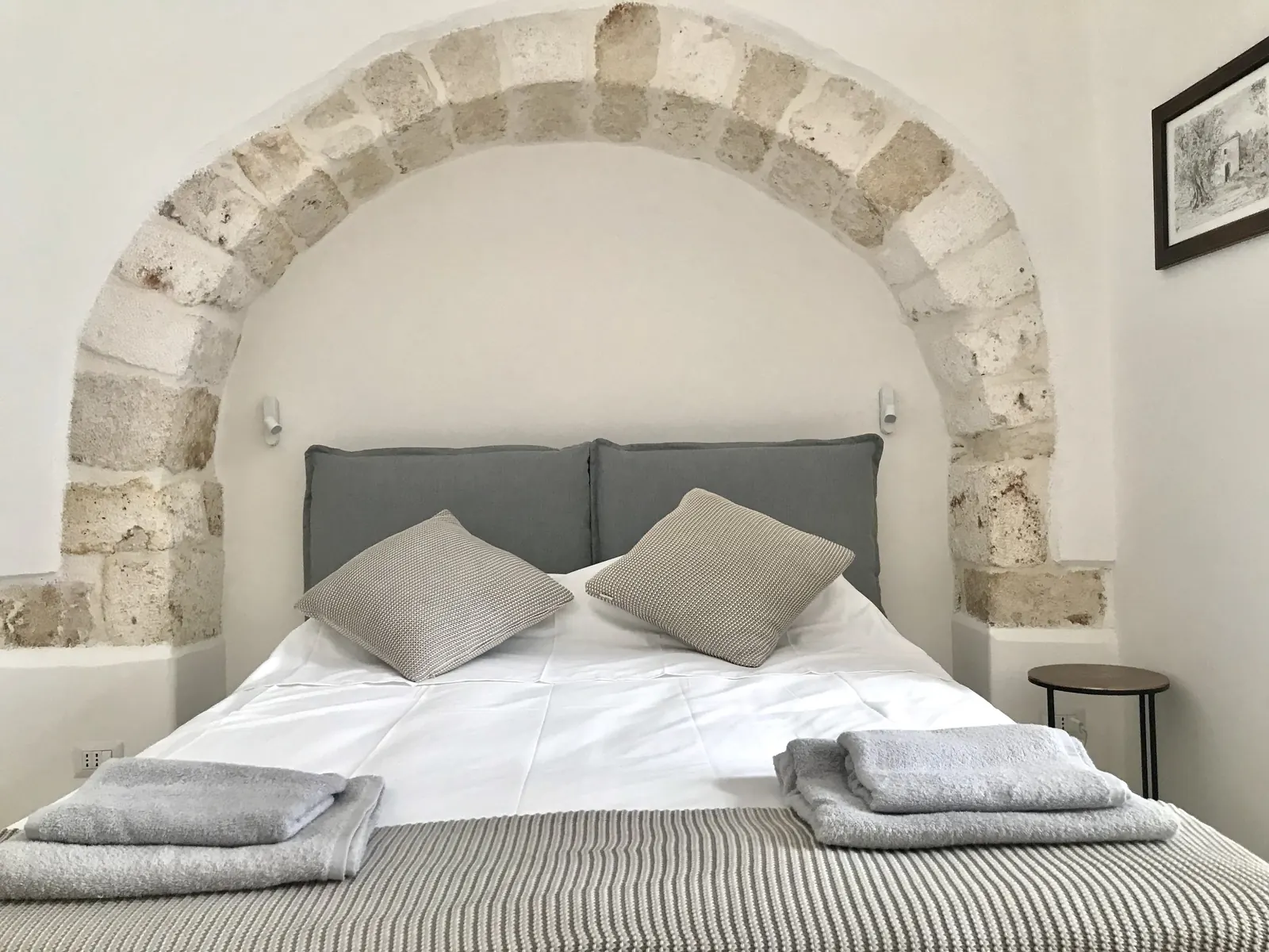 Bed beneath a stone arch